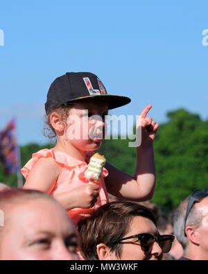 Junge Kind tragen Baseball Cap auf den Schultern ihres Vaters in einer Menschenmenge genießen Gemeinsame Leute Musik Festival 27. Mai 2018 Stockfoto