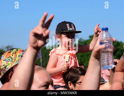 Junge Kind tragen Baseball Cap auf den Schultern ihres Vaters in einer Menschenmenge genießen Gemeinsame Leute Musik Festival 27. Mai 2018 Stockfoto