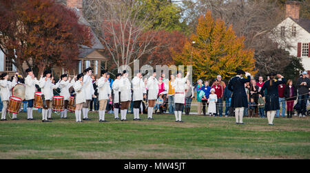 Colonial Williamsburg, Virginia Fife und Drum Corps, die sich in der Ausbildung befinden und der Durchführung für eine große touristische Menschenmenge als blau-beschichteten Offizieren salute Stockfoto