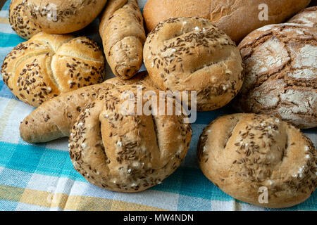 Haufen von verschiedenen Brötchen mit Salz, Kümmel und Sesam. Frische Rustikales Brot aus Hefeteig. Auswahl an frisch von Backwaren Stockfoto