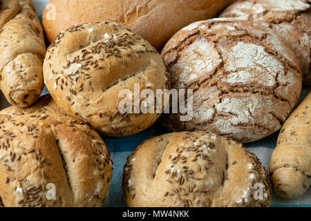 Haufen von verschiedenen Brötchen mit Salz, Kümmel und Sesam. Frische Rustikales Brot aus Hefeteig. Auswahl an frisch von Backwaren Stockfoto