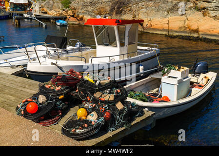 Reusen und Netze auf einem Pier für den Einsatz bereit. Fischerboote vom Pier. Ronnang auf der Insel Tjorn, Schweden. Stockfoto