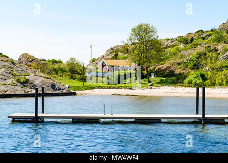 Badestrand Ronnang auf der Insel Tjorn, Schweden. Schönes Haus und Coastal Cliff Landschaft im Hintergrund. Stockfoto