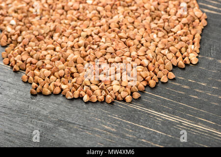 Zerstreut ungekocht Körner von buchweizen auf einer hölzernen Hintergrund Stockfoto