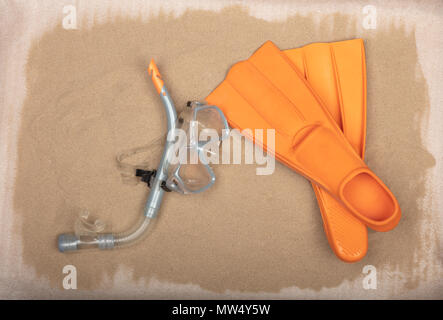 Tauchausrüstung - orange Tauchen Maske, Schnorchel und Flossen auf sandigem Untergrund. Stockfoto