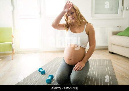 Müde schwangere Frau kämpfen, um wieder in Form zu kommen Stockfoto