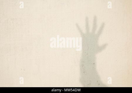 Schatten der menschlichen Hand auf abstrakte Wand Stockfoto