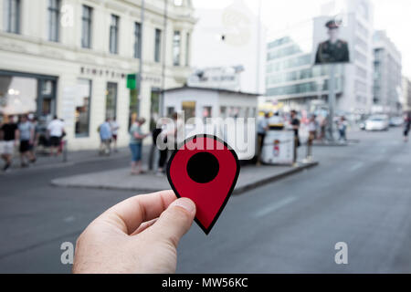 Nahaufnahme der Hand eines jungen kaukasischen Mann mit einer roten Markierung in der beliebten Checkpoint Charlie in Berlin, Deutschland Stockfoto