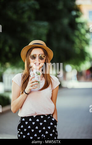 Nachdenklich, glücklich, Frau trank einen Mojito in der Straße im Freien Stockfoto