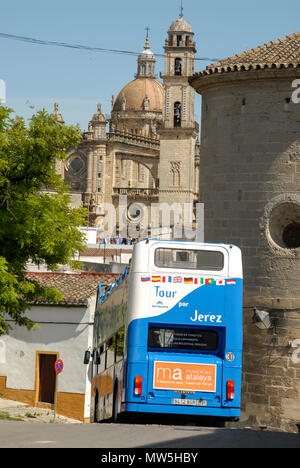 Eine touristische Doppeldecker Bus steigt eine Gasse in der Altstadt von Jerez de la Frontera in Andalusien, Südspanien. Im Hintergrund ist der Stockfoto