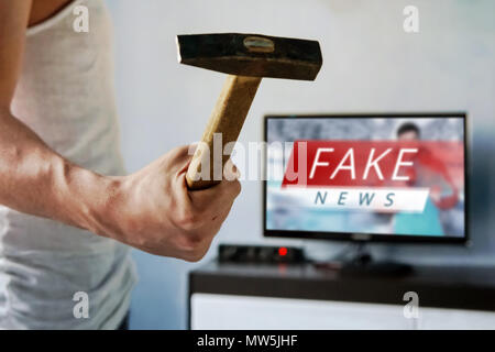 Mann will der TV zu brechen. Kerl schwang ein Hammer auf den Bildschirm. . Gefälschte Nachrichten auf dem TV-Bildschirm, HOAX Konzept. Nachrichten Bericht mit falscher Nachrichten. Wahrheit misreprese Stockfoto