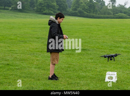 Biracial junge fliegt Drone bei Weald Country Park Model Release statt Stockfoto