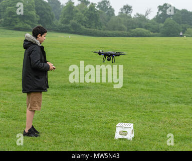 Biracial junge fliegt Drone bei Weald Country Park Model Release statt Stockfoto