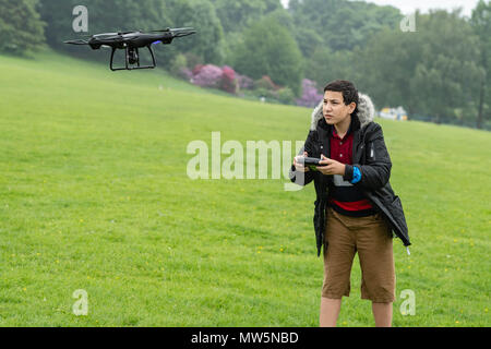 Biracial junge fliegt Drone bei Weald Country Park Model Release statt Stockfoto