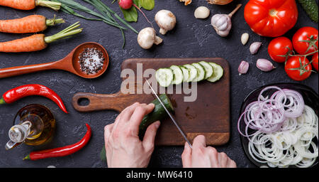 Bild oben auf frisches Gemüse, Pilze, Schneidbrett, Öl, das Messer, die Hände von Cook Stockfoto