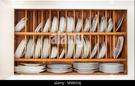 Einrichtung eines alten Holzschrank mit Porzellan Platten auf einer Platte Rack mit Eichenholz gefertigt. Stockfoto