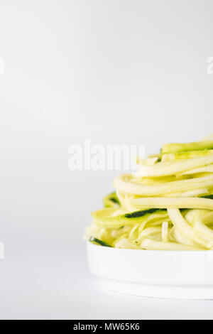 Spiralised Zucchini gegen den weißen Hintergrund mit Platz für Kopieren. Stockfoto