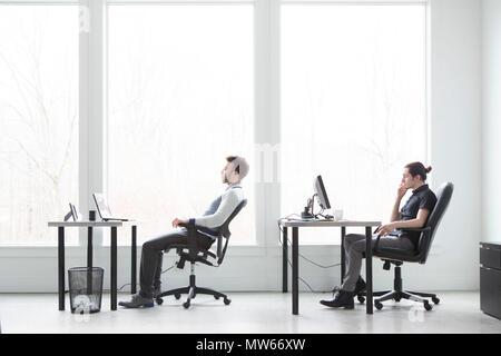Büroangestellte gelangweilt und unmotiviert in einem modernen Büro. Stockfoto