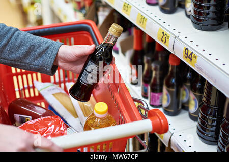 Sojasauce Flasche in der Hand des Käufers im Lebensmittelgeschäft Stockfoto