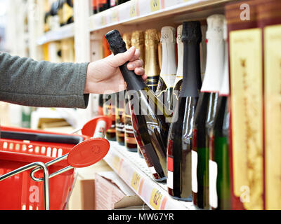 Flasche Champagner in den Händen der Käufer im Store. Stockfoto