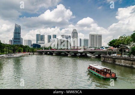 Eine Kreuzfahrt Boot wie die twakows Fahrt durch die berühmten Singapore River bekannt. Das Gebäude an der Rückseite ist die berüchtigte Theater an der Bucht, Esplanade. Stockfoto