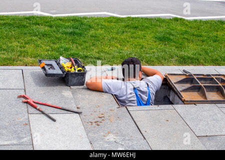 Arbeitnehmer, Reparaturen im Schacht auf Wasserversorgung, an der Straße der Stadt. Stockfoto