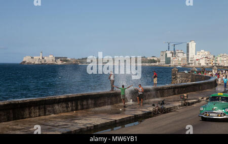 Eine Welle bricht über dem Meer an der Wand der Malecon in Havanna, Kuba, 1. April 2018, schlug einige Männer angeln vom Meer an der Wand. Stockfoto