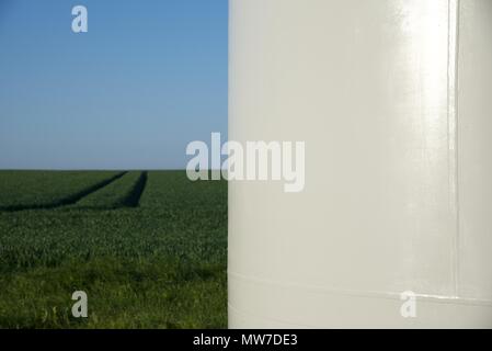 Windenergieanlage: Nahaufnahme einer Windkraftanlage Turm mit einem Bereich der Anbau von Weizen im Hintergrund Stockfoto