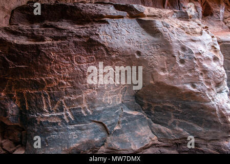 Ancient Nabatean und Thamudic Inschriften auf Stein, camel Caravan und Menschen. Khazali Canyon, Wadi Rum Wüste, Jordanien Stockfoto