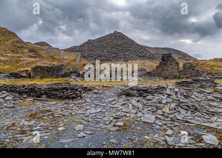 Ein Tipp steht hinter dem dilapitated Gebäude auf dem Gelände der ehemaligen Rhosydd Schiefergrube, Snowdonia National Park stillgelegten Stockfoto