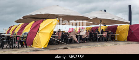 Eine Gruppe von Menschen ein Getränk ein, während die Zuflucht vom kalten Wind genießen, am Sonntag, den 31. Mai 2015, in De Panne, Belgien. Stockfoto