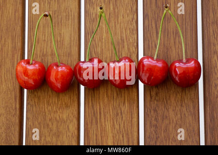 Six cherries lined on a wooden background. Healthy food concept Stockfoto