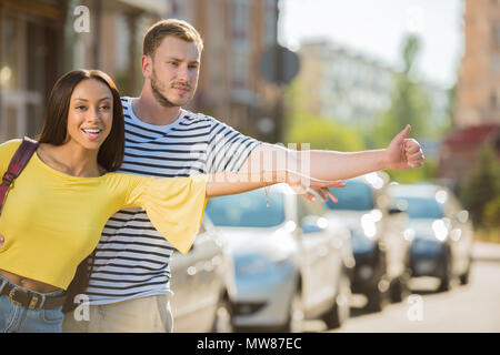 Jungen multiethnischen Paar Touristen hageln Taxi in der Stadt Stockfoto