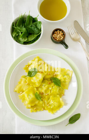 Ravioli mit Ricotta und Spinat, serviert mit Olivenöl und Pinienkernen. Im rustikalen Stil. Stockfoto