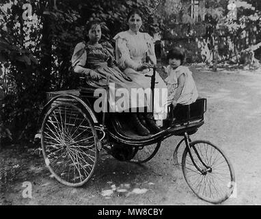 . English: Foto mit Thilde, Clara und Ellen Benz (von links) auf einem Patent-Motorwagen. Englisch: Foto mit Thilde, Clara und Ellen Benz sitzen auf einem Patent-Motorwagen. ca. 1900. Unbekannt 80 Benz-Patent-Motorwagen-mit-Thilde, - Clara-und-Ellen-Benz Stockfoto