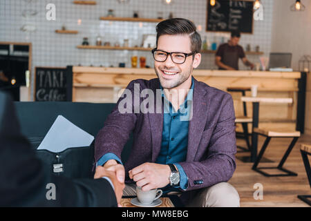 Unternehmer die Hände schütteln während der Tagung in Kaffees hop Stockfoto