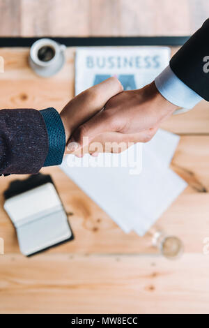 7/8 shot der Unternehmer die Hände schütteln während der Sitzung im Cafe Stockfoto