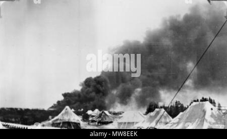 . Englisch: Haifa, Palästina, 1940-07-15. Schwarzer Rauch aufsteigt, von Öltanks, die auf Feuer im ersten Luftangriff auf den Hafen der Stadt eingerichtet wurden, durchgeführt von 40 Flugzeugen der italienischen Luftwaffe. Im Vordergrund stehen die Zelte der 2/1 Feld st Regiment, 2. AIF, die Anti-Flugzeuge war die Verteidigung. (Spender D. Hulme-Moir). 15. Juli 1940. Hulme-Moir, F 90 Bombardierung von Haifa 8. Stockfoto