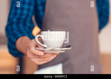 7/8 Schuß von Barista holding Tasse aromatischen Kaffee in der Hand Stockfoto