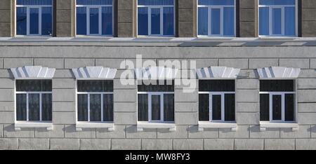 Textur einer verglasten modernen Windows von einem Gebäude aus grauem Beton. Nahaufnahme einer Betonwand mit Kunststofffenster Stockfoto