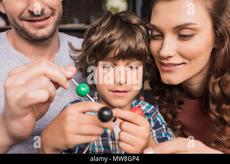 Jugendliche und junge Eltern spielen zusammen mit Atomen Modell Stockfoto