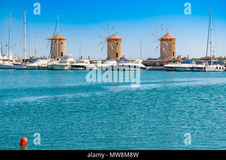 Windmühlen hinter der Boote und Yachten in Mandraki Hafen in der Stadt Rhodes (Rhodos, Griechenland) Stockfoto