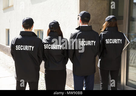 Ansicht der Rückseite des Security Guards tragen Einheitliche stehen in einer Reihe Stockfoto