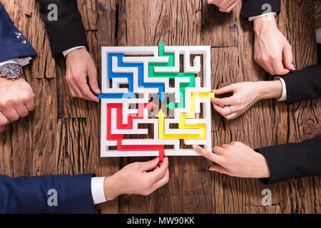 Erhöhten Blick auf Geschäftsleute Hand Lösung Labyrinth zusammen auf Holz- Hintergrund Stockfoto