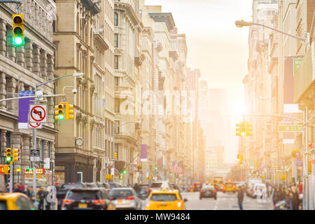 Sonnenlicht strahlt am Broadway in New York City mit Menschen und Autos die Straße säumen. Durch Midtown Manhattan Stockfoto