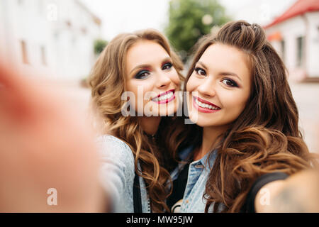 Recht jugendlich Mädchen mit Frisuren und roten Lippen in die Kamera lächelt. Stockfoto