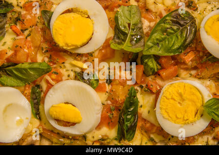 Nahaufnahme der selektiven Fokus der leckere Pizza mit Salami, Mozzarella und Tomaten Sauce, gekochte Eier in Stücken Stockfoto