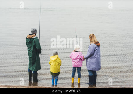 Rückansicht der Familie Angeln zusammen an regnerischen Tag Stockfoto