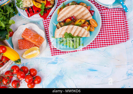 Mexikanische Tacos mit gegrilltem Gemüse und Lachs. Gesundes Essen für die Mittagspause. Fast food. Platz kopieren Stockfoto