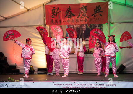 Chinesische Mädchen führen Sie einen Chinesischen Tanz mit Lüftern für die Feierlichkeiten zum Chinesischen Neuen Jahr in Manchester, Großbritannien Stockfoto